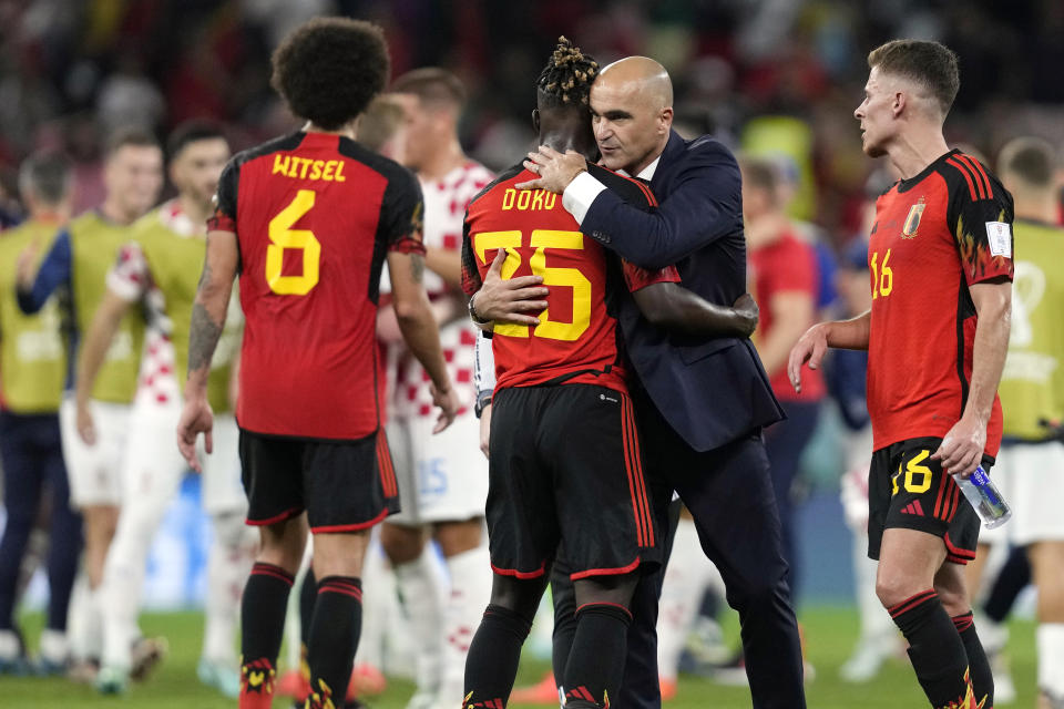 Belgium's head coach Roberto Martinez embraces Belgium's Jeremy Doku after their team was defeated at the World Cup group F soccer match between Croatia and Belgium at the Ahmad Bin Ali Stadium in Al Rayyan, Qatar, Thursday, Dec. 1, 2022. (AP Photo/Thanassis Stavrakis)