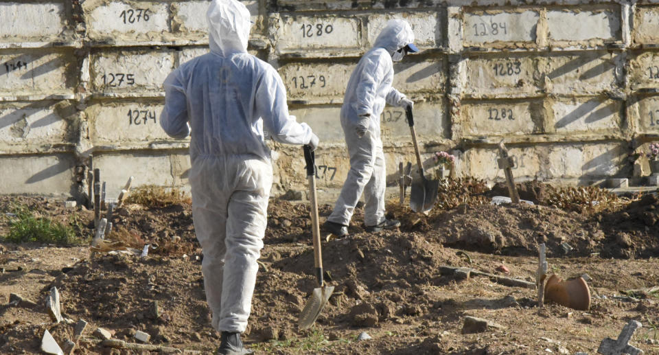 Workers tend to burials of Covid-19 victims in Cemiterio do Caju, North Zone of Rio de Janeiro, on April 1. Source: Getty Images