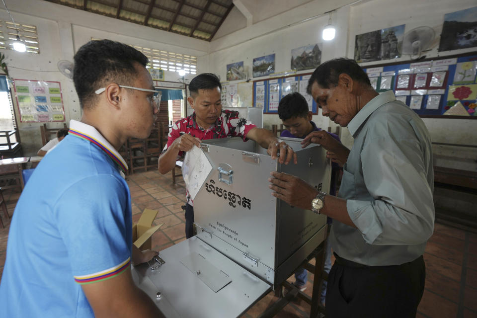 Pulling station members prepare a ballot box for villagers to vote next day at a polling station on the outskirts of Phnom Penh, Cambodia, Saturday, July 22, 2023. Hun Sen has been Cambodia's autocratic prime minister for nearly four decades, during which the opposition has been stifled and the country has moved closer to China. Cambodia sets Sunday for voting. (AP Photo/Heng Sinith)