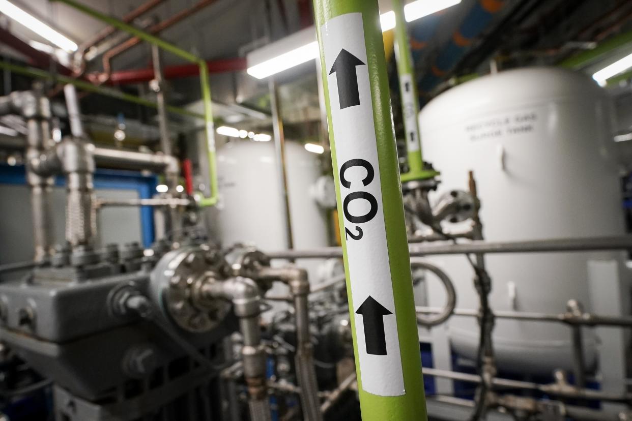 A liquid carbon dioxide pipe is labeled in a production room of The Grand Tier luxury apartment building, where the carbon byproduct of a natural gas fired water boiler is repurposed for industrial sale, Tuesday, April 18, 2023, in New York. New York is forcing buildings to clean up, and several are experimenting with capturing carbon dioxide, cooling it into a liquid and mixing it into concrete where it turns into a mineral. (AP Photo/John Minchillo)