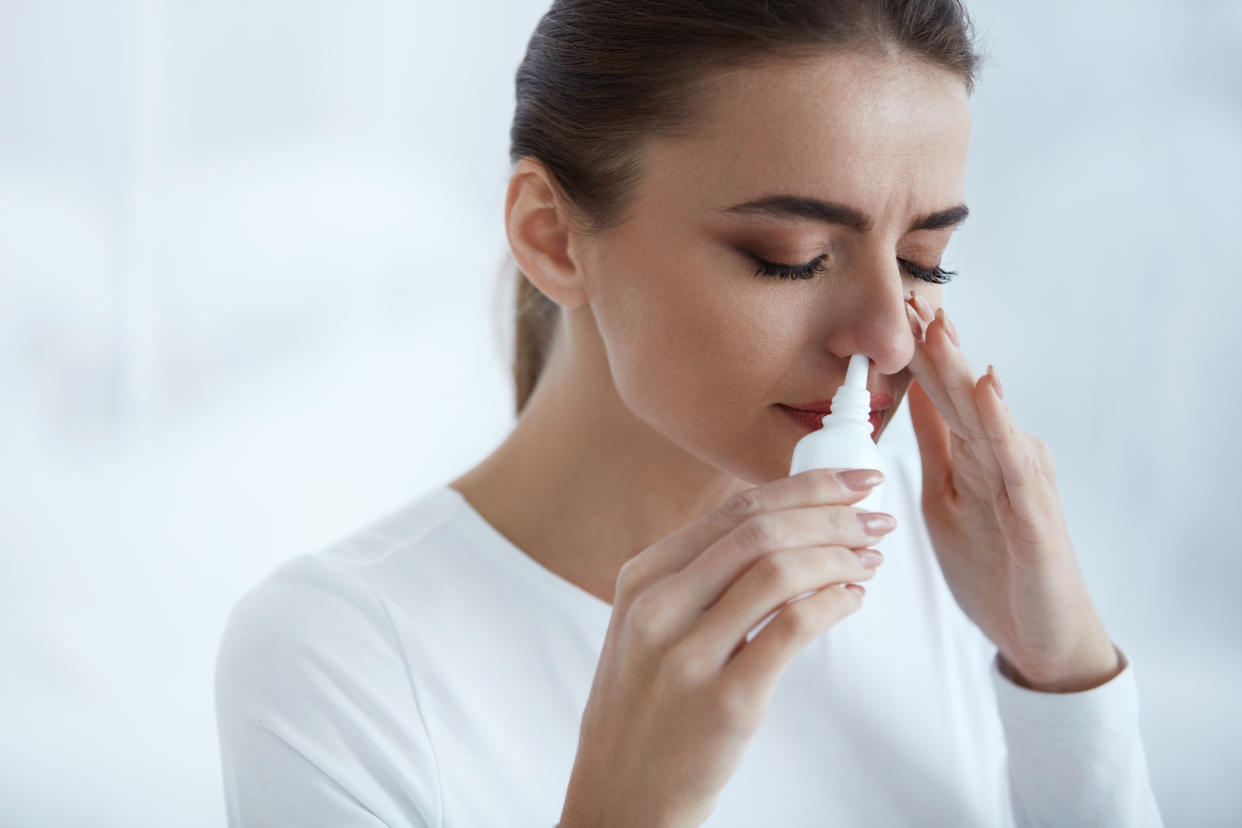 Cold. Portrait Of Beautiful Young Woman Sniffing Nasal Spray Closing One Nostril. Closeup Of Female Feeling Sick With Running Nose Using Sinus Medication For Blocked Nose. Healthcare. High Resolution