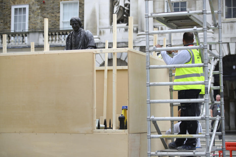 A protective hoarding is erected around a statue of Thomas Guy, outside Guy's hospital in London, following a raft of Black Lives Matter protests across the UK. Protests sparked by the death of George Floyd, who was killed while in police custody in the US city of Minneapolis, has sparked a wider debate about the UK's colonial past. Guy's and St Thomas' NHS Foundation Trust confirmed two figures depicting Robert Clayton and Thomas Guy will be taken out of public view due to their association with the slave trade. (Aaron Chown/PA via AP)