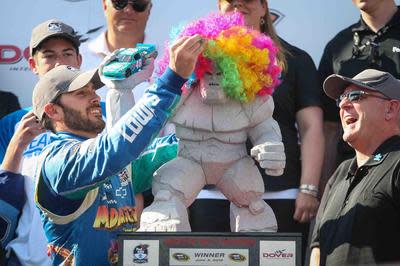 Jimmie Johnson celebrates one of his 11 victories at Dover, in 2012, by placing a rainbow-colored wig over the Miles the Monster trophy.