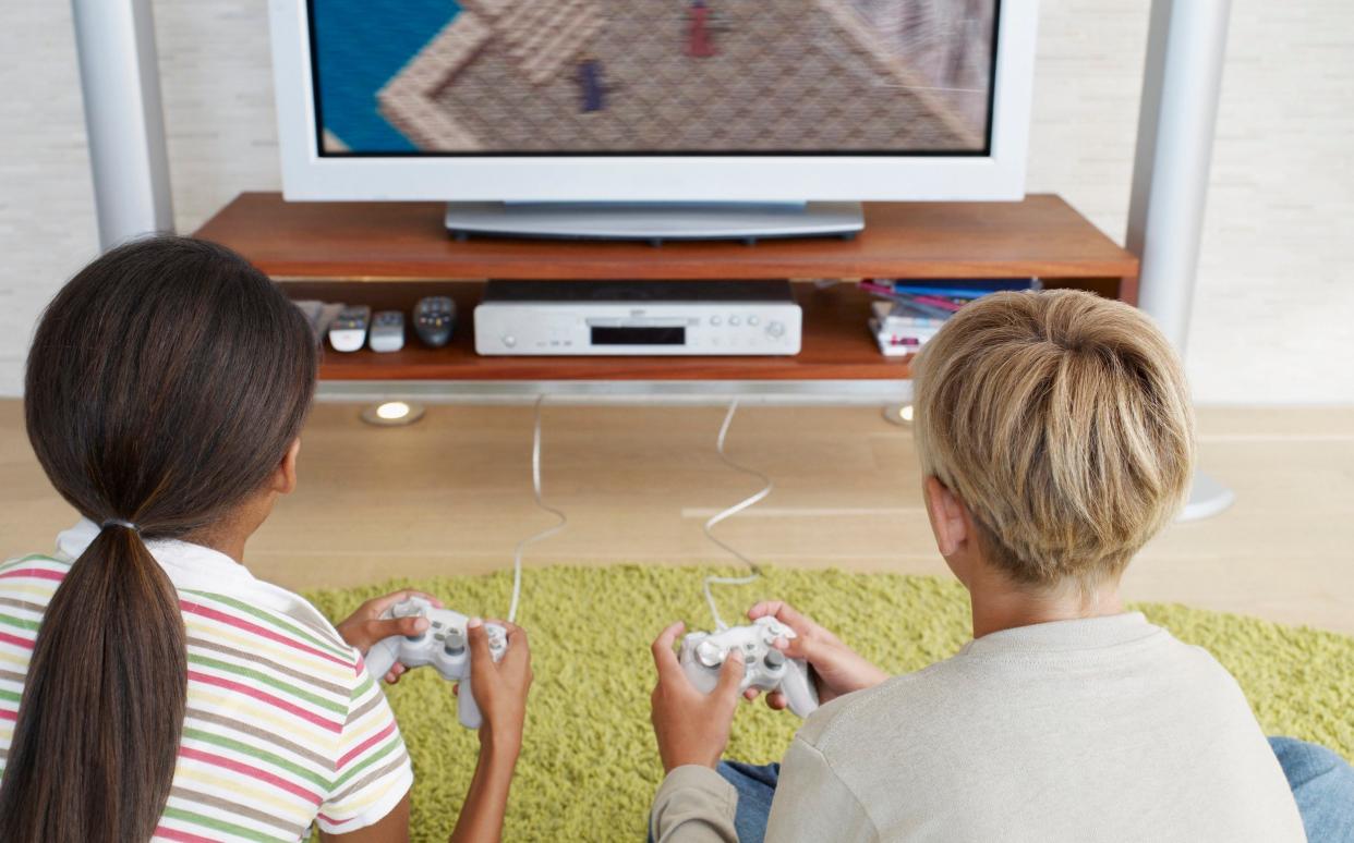 Two young kids playing video games