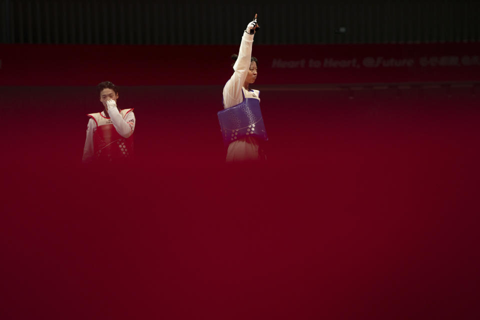 South Korea's Lee Dabin, left, and China's Zhou Zeqi react after the taekwondo women's +67kg final at the 19th Asian Games in Hangzhou, China, Wednesday, Sept. 27, 2023. (AP Photo/Louise Delmotte)