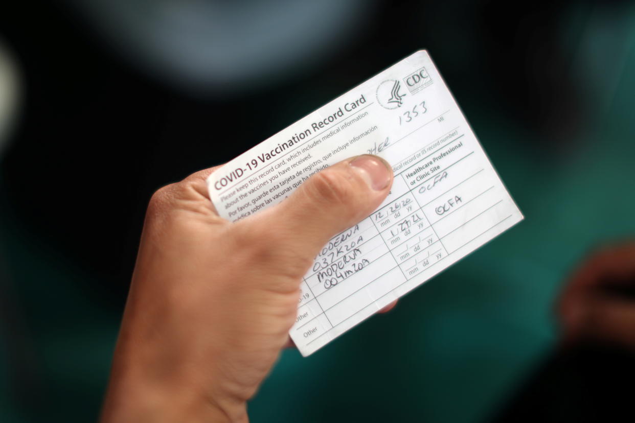 An Orange County firefighter holds his vaccination card after receiving the coronavirus disease (COVID-19) vaccine in Irvine, California, U.S., January 27, 2021. REUTERS/Lucy Nicholson