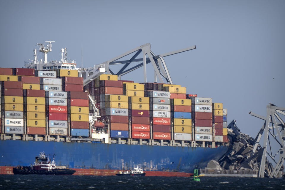 A tugboat floats next to the container ship Dali lodged against the wreckage of the Francis Scott Key Bridge, Friday, March 29, 2024, in Baltimore, Md. (AP Photo/Mark Schiefelbein)