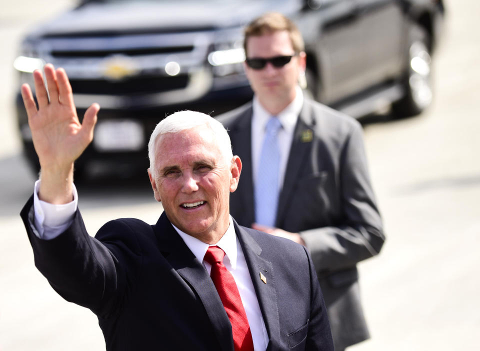 Vice President Mike Pence waves to the media after landing at the Roanoke-Blacksburg Regional Airport before heading to the National D-Day Final Salute 75th Anniversary Commemorative Ceremony in Bedford, Va., Thursday, June 6, 2019. (Emilee Chinn/The Roanoke Times via AP)