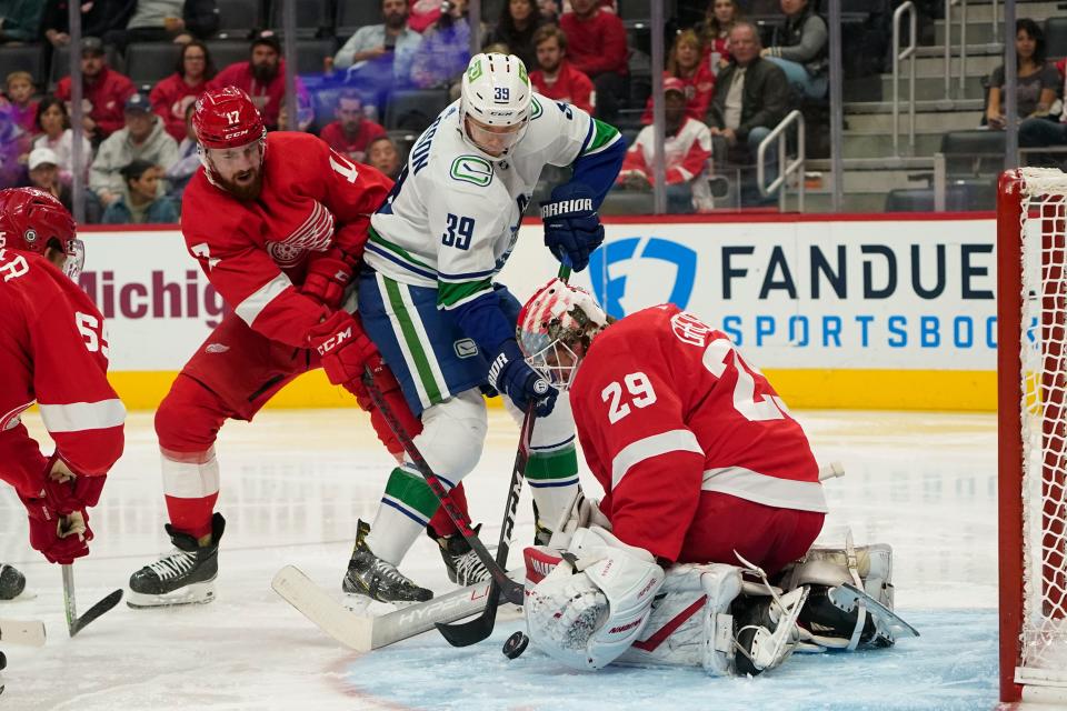 Red Wings goaltender Thomas Greiss stops a Canucks right wing Alex Chiasson shot as Nick Leddy defends during the second period on Saturday, Oct. 16, 2021, at Little Caesars Arena.
