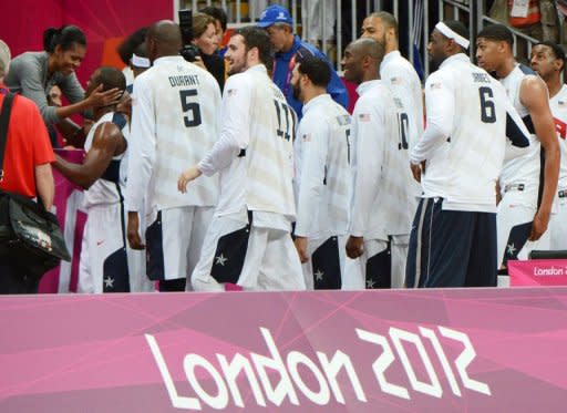 US basketball players are congratulated by US First Lady Michelle Obama after they won 98-71 the Men's Preliminary Round Group A match United States vs France at the London 2012 Olympic Games, in London