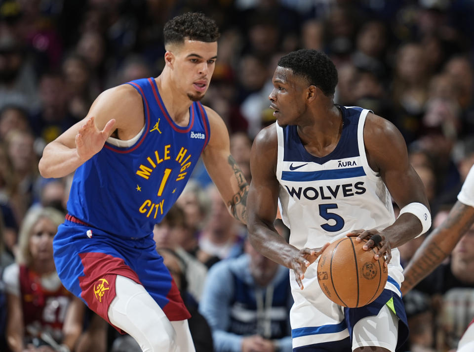 Minnesota Timberwolves guard Anthony Edwards, right, looks to pass the ball as Denver Nuggets forward Michael Porter Jr. defends in the first half of Game 1 of an NBA basketball second-round playoff series Saturday, May 4, 2024, in Denver. (AP Photo/David Zalubowski)