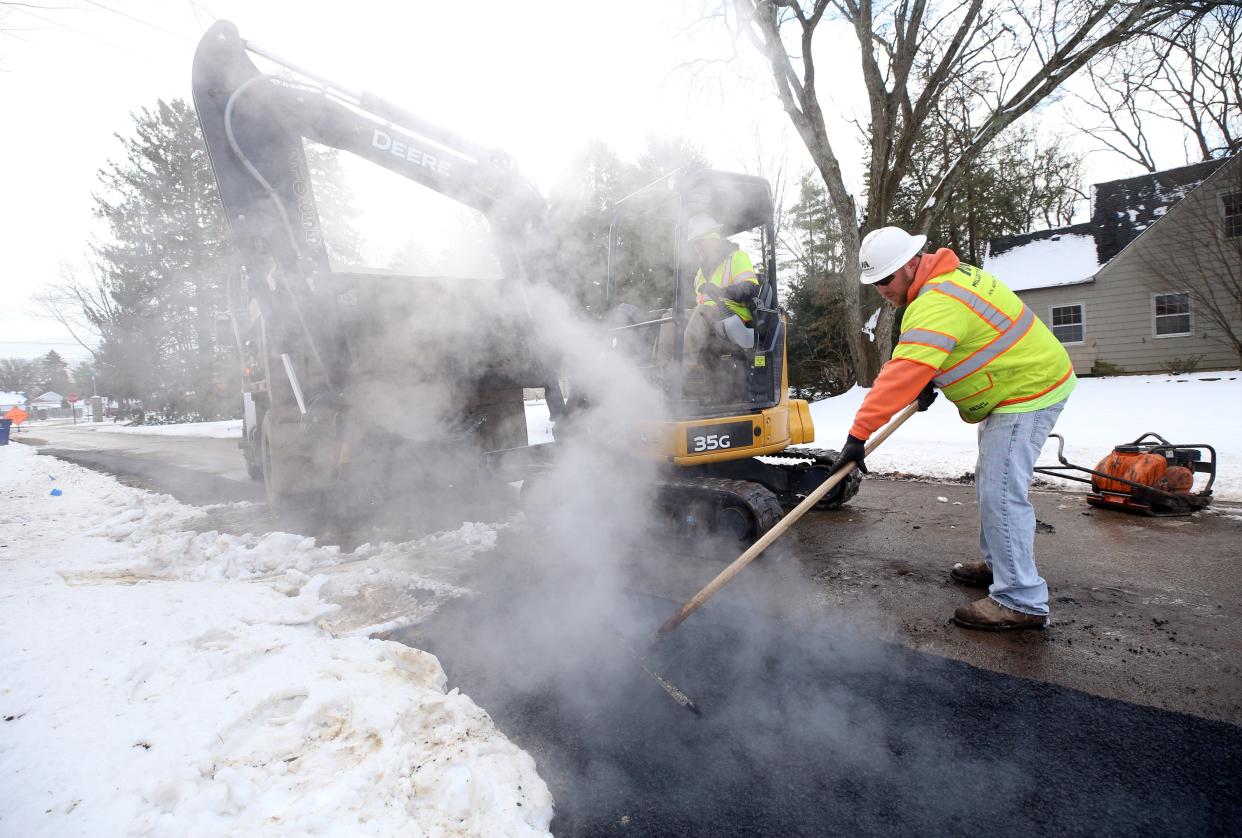Randy Himes (left) and Clark Holliday, both with Miller Pipeline, pave an area on Royal Forest Boulevard on Jan. 19 where Columbia Gas of Ohio crews have been installing new lines.