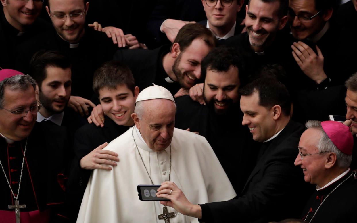 Pope Francis poses for a photo with a group of priests at the end of his weekly general audience in the Paul VI Hall at the Vatican Wednesday, Feb. 20, 2019 - AP