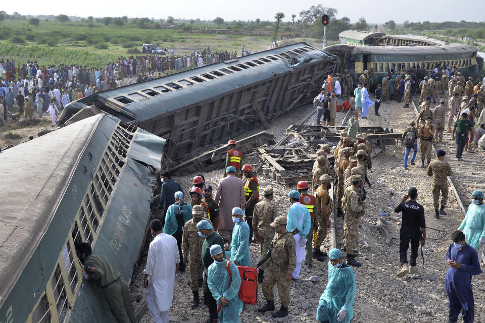 Rescue workers and army troops take in a rescue operation at the site of train derailed outskirts of Sarhari railway station Nawabshah, Pakistan, Sunday, Aug. 6, 2023. Railway officials say some passengers were killed and dozens more injured when a train derailed near the town of Nawabshah in southern Sindh province. (AP Photo/Pervez Masih)