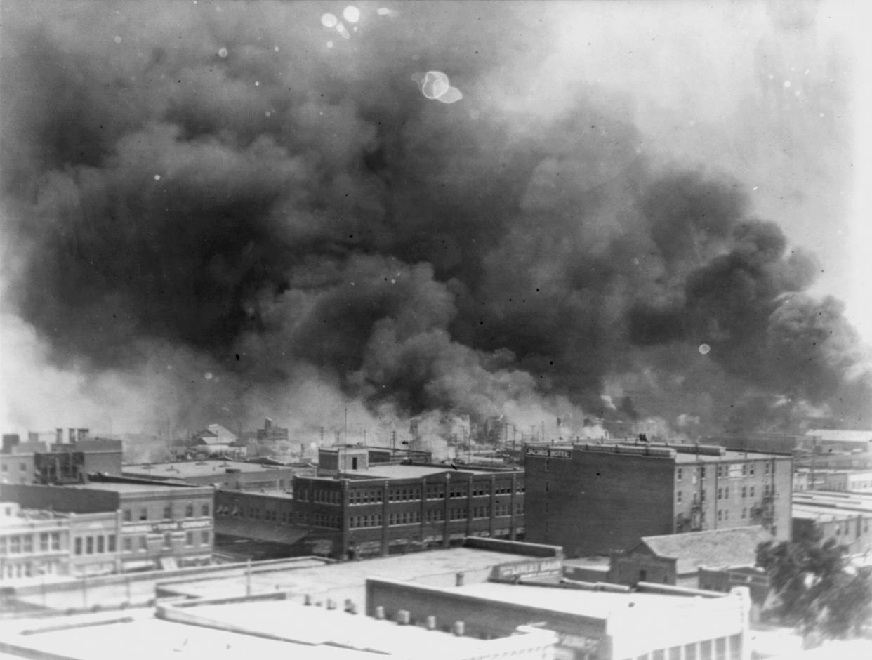 In a black-and-white image, smoke billows over downtown Tulsa.