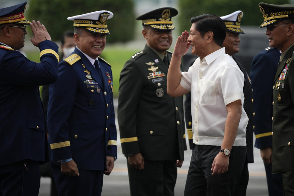 Philippine President Ferdinand Marcos Jr., salutes during departure honors as he boards a plane for China on Tuesday, Jan. 3, 2023, at the Villamor Air Base in Manila, Philippines. (AP Photo/Aaron Favila)