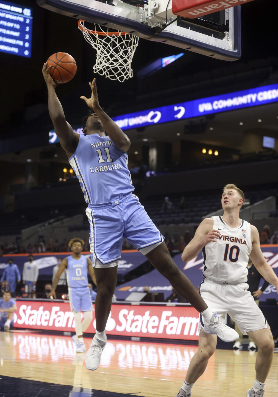 North Carolina forward Day'Ron Sharpe (11) shoots next to Virginia forward Sam Hauser (10) during an NCAA college basketball game Saturday, Feb. 13, 2021, in Charlottesville, Va. (Andrew Shurtleff/The Daily Progress via AP, Pool)