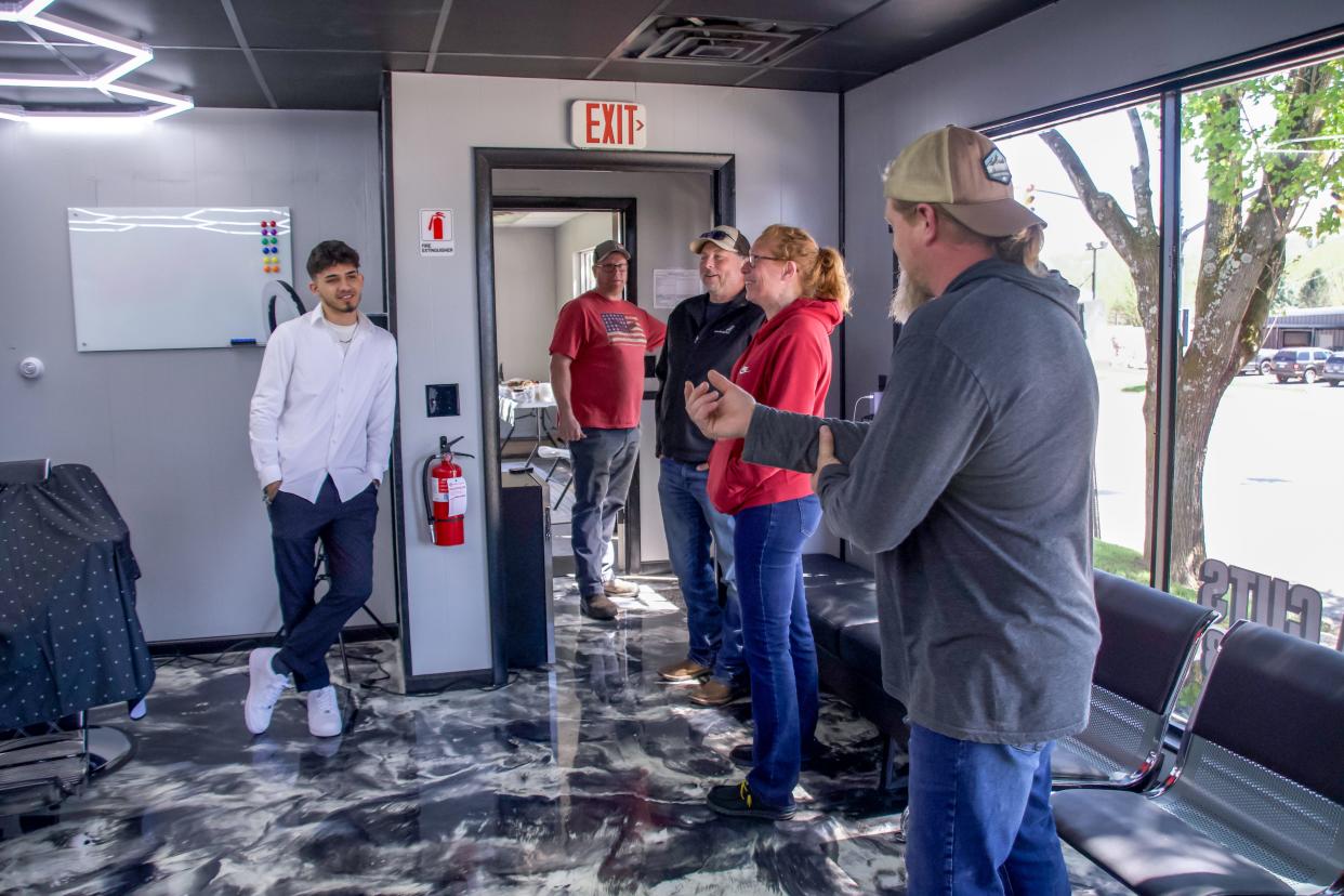 Clayton Arena (left) visits with family and guests during the grand opening celebration of Arena Cuts in New Concord.