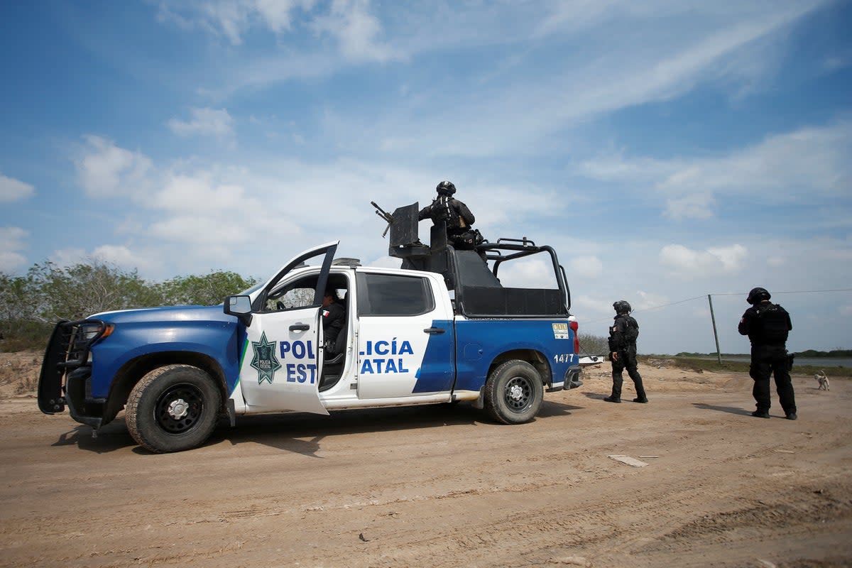 File. State police officers keep watch at the scene where authorities found the bodies of two of four Americans kidnapped by gunmen, in Matamoros, Mexico, 7 March 2023. - On Saturday, a band of gunmen invaded a resort in central Mexico and shot at the vacationers killing seven  (REUTERS)