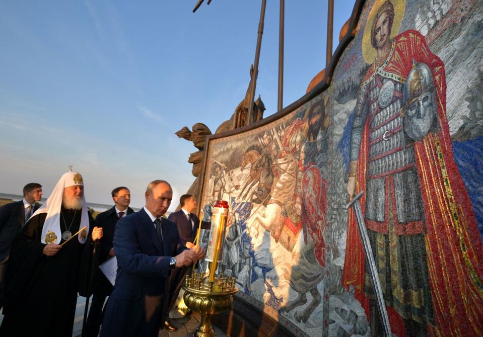 Russian President Vladimir Putin (R) lights a candle unveiling a huge monument to legendary Russian medieval prince Alexander Nevsky in the village of Samolva, outside Pskov on Sept. 11. 2021. (Alexey Druzhinn /SPUTNIK/AFP via Getty Images)