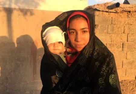 An Afghan refugee poses with her child at the Bardsir settlement for Afghan refugees in Kerman province, Iran, October 22, 2016. REUTERS/Gabriela Baczynska