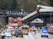 <p>DEC. 18, 2017 – Emergency crews work at the scene of a Amtrak train derailment in DuPont, Washington. At least three people were killed when a passenger train car plunged from the bridge. The derailment also closed southbound I-5. (Photo: Stephen Brashear/Getty Images) </p>