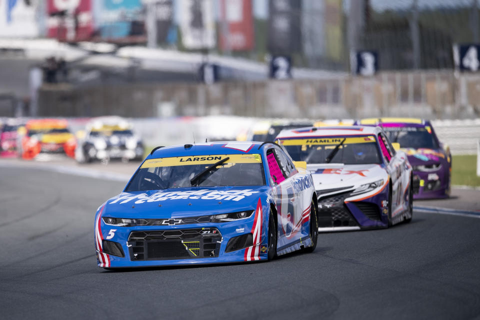 Kyle Larson (5) leads a pack of cars during a NASCAR Cup Series auto racing race at Charlotte Motor Speedway, Sunday, Oct. 10, 2021, in Concord, N.C. (AP Photo/Matt Kelley)