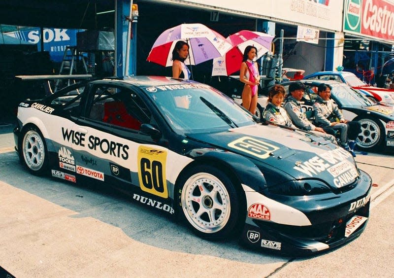 a toyota cavalier race car in the pit box at a race track in the late 1990s