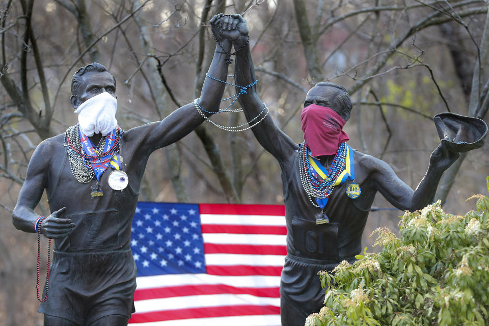 The Young at Heart Johnny Kelley statue by Rich Muno on Commonwealth Avenue wears a mask, Mardi Gras beads and Boston Marathon medals. (Matthew J. Lee/The Boston Globe via Getty Images)