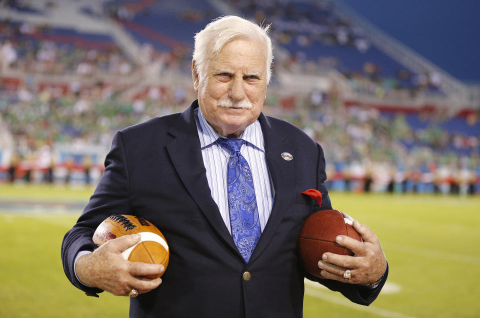 In this Dec. 23, 2014 photo, former Florida Atlantic and Miami head coach, Howard Schnellenberger holds the game balls prior to the start of the Boca Raton Bowl NCAA college football game between Marshall and Northern Illinois at FAU Stadium in Boca Raton, Fla. Schnellenberger, who coached Miami to the 1983 national championship and built programs at Louisville and Florida Atlantic, died Saturday, March 27, 2021, at the age of 87, Florida Atlantic announced. (AP Photo/Joel Auerbach)