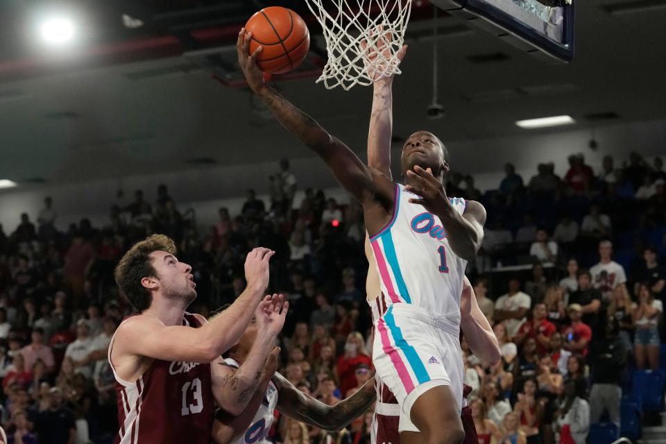 Florida Atlantic guard Johnell Davis (1) drives to the basket over Charleston forward Ben Burnham (13) during the first half of an NCAA college basketball game, Saturday, Dec. 2, 2023, in Boca Raton, Fla. (AP Photo/Marta Lavandier)