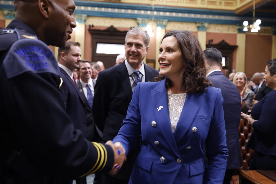 Michigan Gov. Gretchen Whitmer, right, greets Michigan State Police director Col. James F. Grady II before delivering her State of the State address to a joint session of the House and Senate, Wednesday, Jan. 24, 2024, at the state Capitol in Lansing, Mich. (AP Photo/Al Goldis)