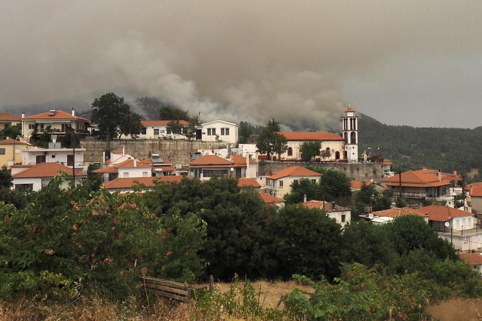 Flames burn a forest during a wildfire in Kourkouloi village on the island of Evia, about 150 kilometers (93 miles) north of Athens, Greece, Thursday, Aug. 5, 2021. Forest fires fueled by a protracted heat wave raged overnight and into Thursday in Greece, threatening the archaeological site at the birthplace of the modern Olympics and forcing the evacuation of dozens of villages. (AP Photo/Thodoris Nikolaou)