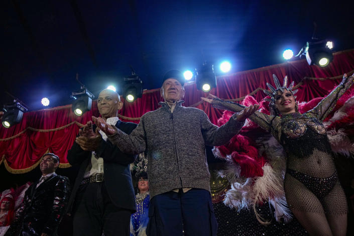Founder of the Timoteo Circus René Valdés and his cast, take a bow at the end of their show, on the outskirts of Santiago, Chile, Saturday, Dec. 10, 2022. The show began in 1968 when one of the circus’ female dancers was absent for a performance. Valdés had one of the male performers dress as a woman and replace her on stage. The performance was so popular the dancer did five curtain calls to receive applause. The transformation circus was born and has been committed to sexual diversity ever since. (AP Photo/Esteban Felix)