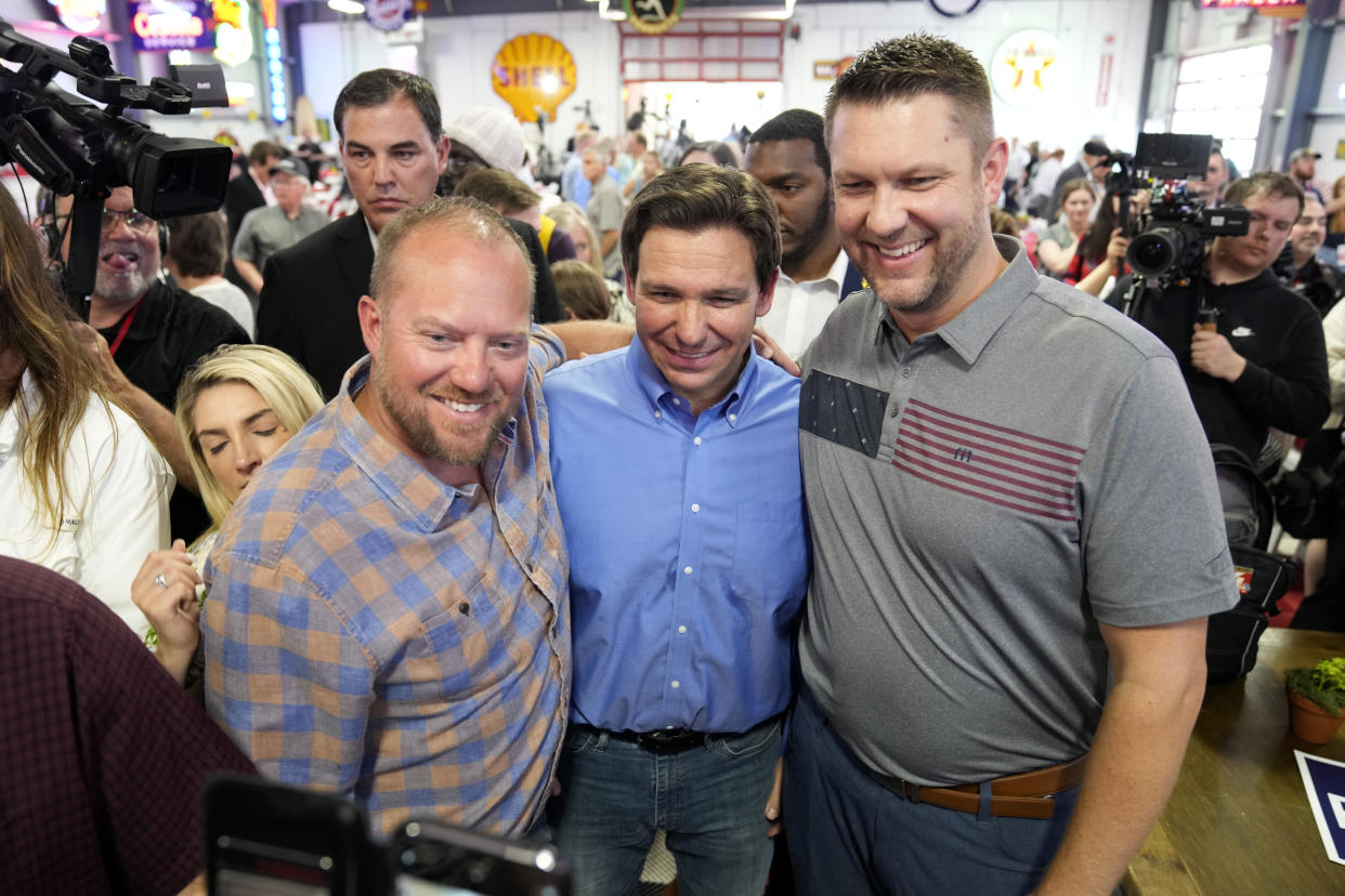 Florida Gov. Ron DeSantis, center, poses for a photo with audience members during a fundraising picnic for Rep. Randy Feenstra, R-Iowa, May 13, 2023, in Sioux Center, Iowa. DeSantis is kicking off his presidential campaign in Iowa at the start of a busy week that will take him to 12 cities in three states as he tests his pitch as the most formidable Republican challenger to former President Donald Trump. (AP Photo/Charlie Neibergall)