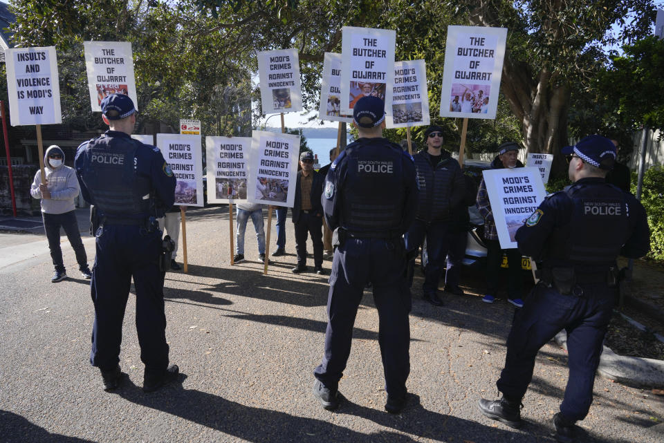 Police stand near protesters outside Kirribilli House where Indian Prime Minister Narendra Modi and Australian Prime Minister Anthony Albanese will hold talks in Sydney, Australia, Wednesday, May 24, 2023. (AP Photo/Rick Rycroft)