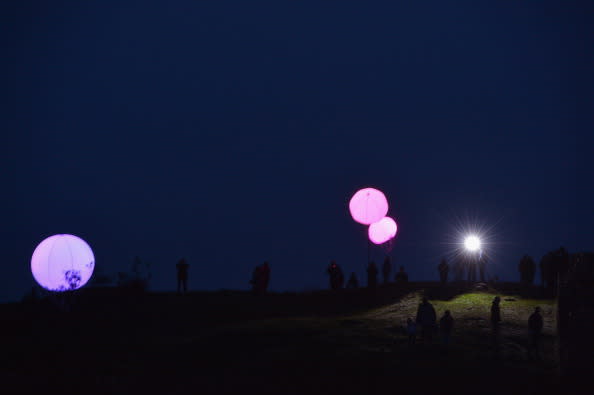 Members of the public view the art installation New York based digital arts collective YesYesNo with founding member Zachary Lieberman, Connecting Light which is part of the London 2012 Festival on August 31, 2012 in Hexham, England. Connecting Light will take place across the 73 miles of Hadrian's Wall on August 31 and September 1. Over 400 two metre diameter tethered balloons will transmit messages between each other, with internal LED lights changing colour in response. The installation becomes a line of pulsating colours as messages travel through it, turning what was once a protective border into a line of luminous communication. The installation will be visible in the evening and accessible to visitors at several locations along the wall. It has also been designed to be viewed remotely all over the world using digital media. (Photo by Jeff J Mitchell/Getty Images)