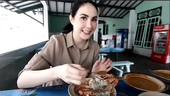 Perempuan kelahiran Jakarta 27 tahun silam itu tampak santai makan, rajungan dengan bumbu super pedas. Rajungan menjadi salah satu yang terkenal di daerah Tuban. (Youtube/Arumi Bachsin)