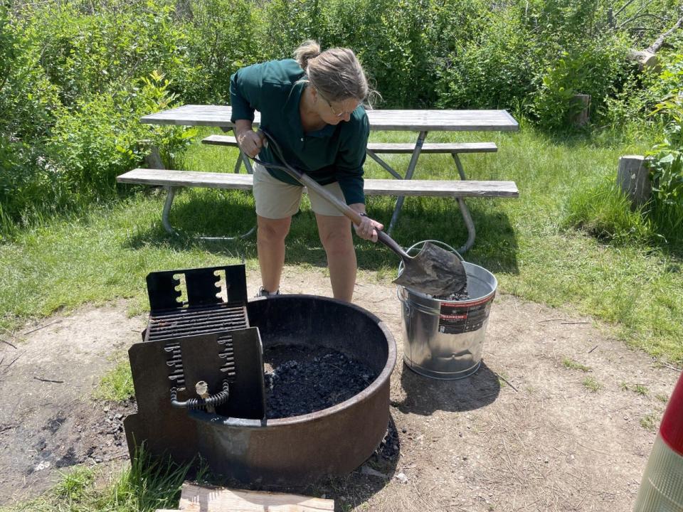 Nancy Gilliom removes ash from a fire pit at Harrington Beach State Park where she was volunteering as a camp host.