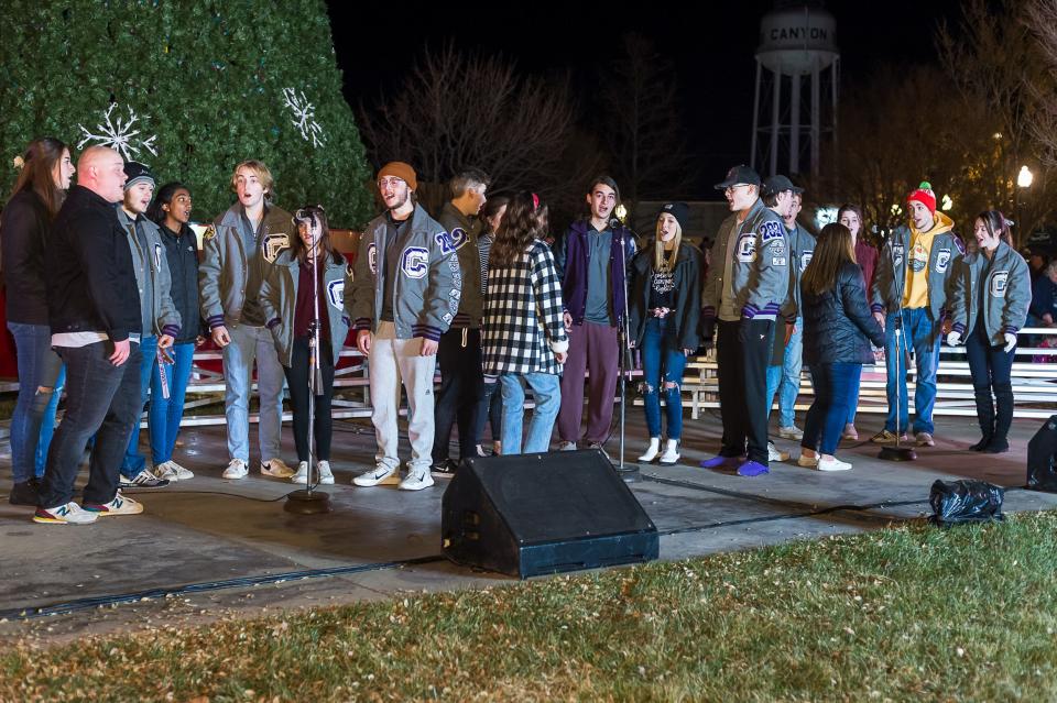 The Canyon High School show choir performs for the crowd prior to the lighting of the Christmas tree on Saturday evening at the city of Canyon's Parade of Lights holiday kickoff.