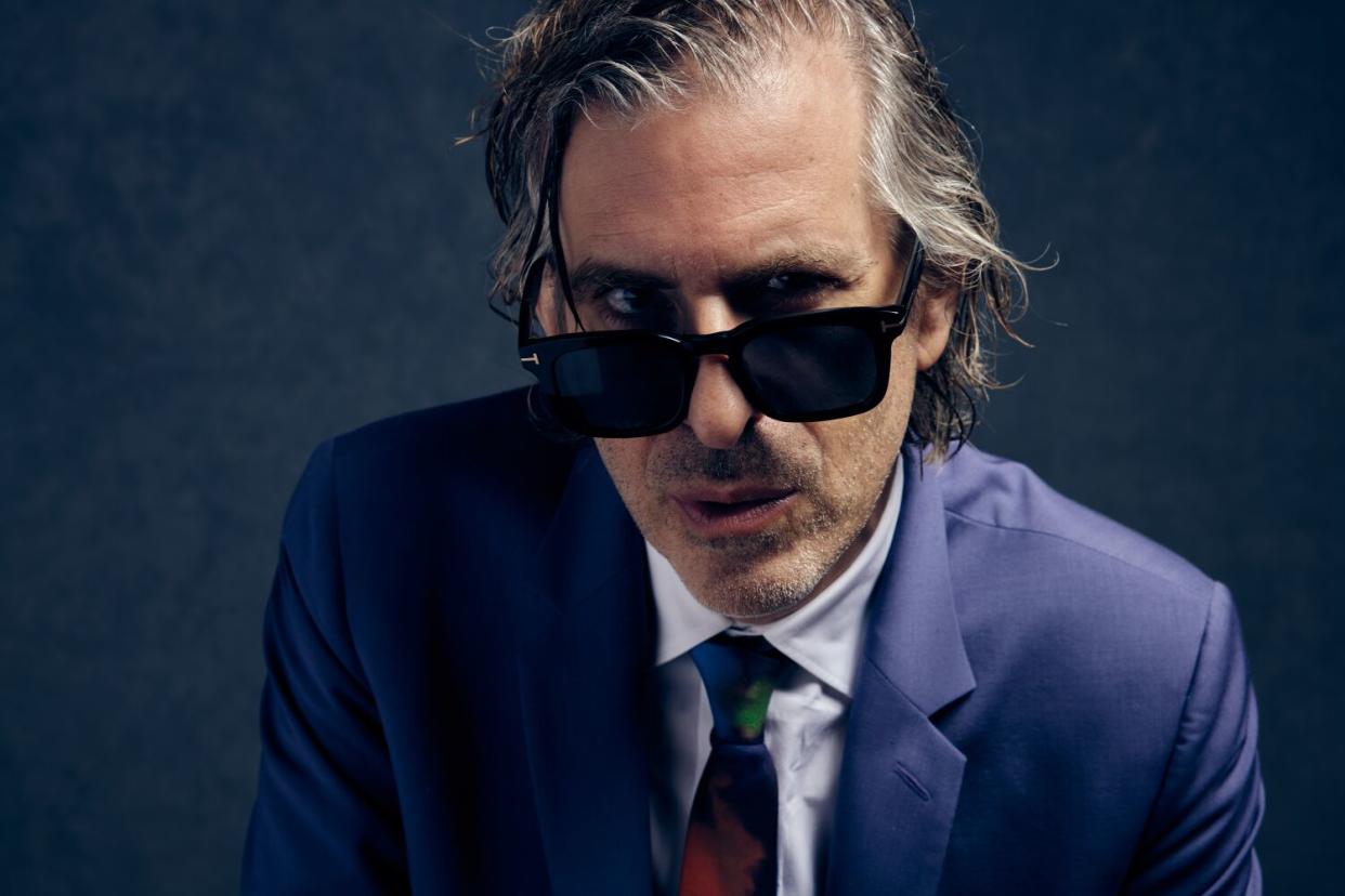 Director Brett Morgen peers over the top of dark sunglasses for a portrait.