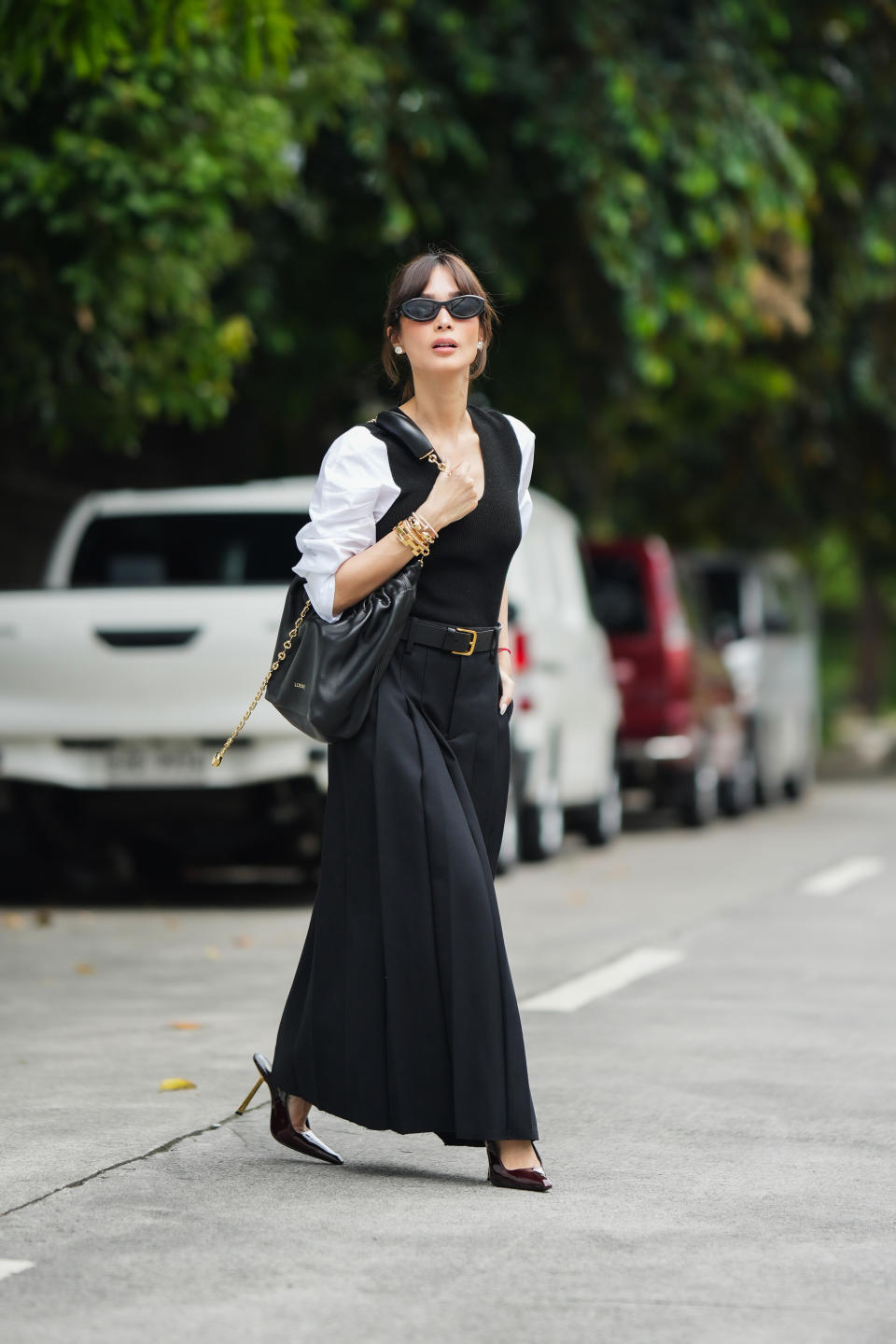 MANILA, PHILIPPINES - NOVEMBER 18: Heart Evangelista wears Prada sunglasses, a white shirt, a black wool ribbed low-neck tank top, a dark navy blue pleated long maxi skirt