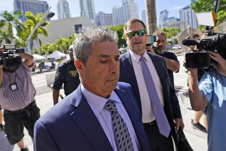 Carlos De Oliveira, center, an employee of Donald Trump's Mar-a-Lago estate, arrives for a court appearance with attorney John Irving, at the James Lawrence King Federal Justice Building, Monday, July 31, 2023, in Miami. De Oliveira, Mar-a-Lago's property manager, was added last week to the indictment with Trump and the former president's valet, Walt Nauta, in the federal case alleging a plot to illegally keep top-secret records at Trump's Florida estate and thwart government efforts to retrieve them. (AP Photo/Wilfredo Lee)