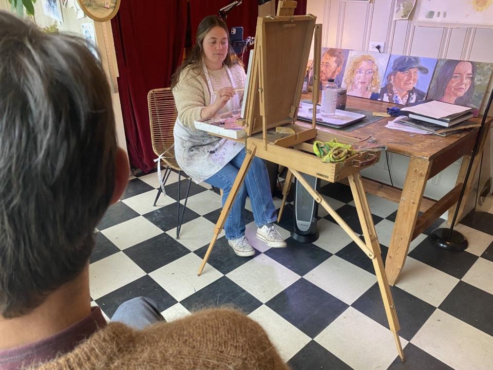 With some of the other portraits she's painted nearby, artist Janie Kinnane paints Little Compton resident Chris Goulart.