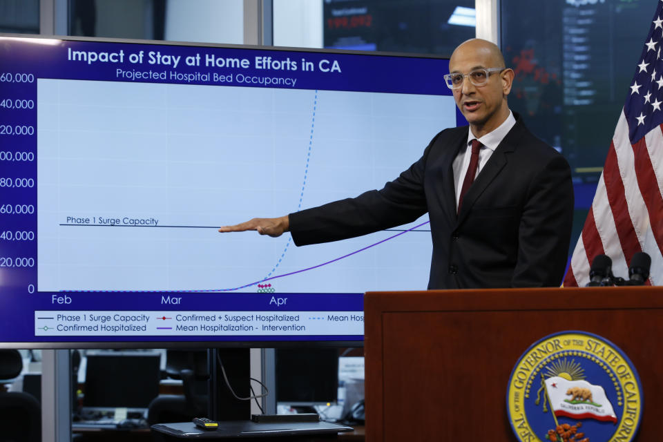 Dr. Mark Ghaly, secretary of the California Health and Human Services, gestures to a chart showing the impact of the mandatory stay-at-home orders during a news conference on the state's response to the coronavirus, at the Governor's Office of Emergency Services in Rancho Cordova, Calif. in Rancho Cordova, Calif., Wednesday, April 1, 2020. Gov. Gavin Newsom announced that California schools will likely remain closed for the rest of the school year, but provide off-site education due to coronavirus pandemic.(AP Photo/Rich Pedroncelli, POOL)