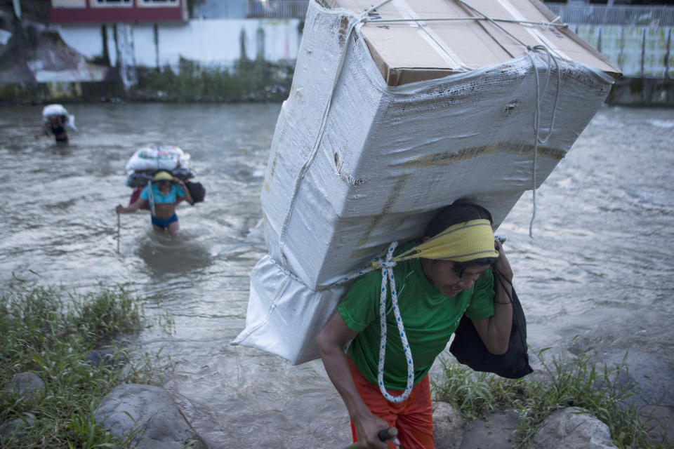 Men carry loads of supplies as they cross the Suchiate river from Guatemala into Talisman, Mexico, Friday, June 21, 2019. Mexico's foreign minister says that the country has completed its deployment of some 6,000 National Guard members to help control the flow of Central American migrants headed toward the U.S.(AP Photo/Oliver de Ros)