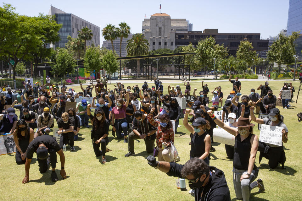 Demonstrators kneel as they take part in a protest Thursday, June 4, 2020, in downtown Los Angeles over the death of George Floyd, who died May 25 after being restrained by police in Minneapolis. (AP Photo/Damian Dovarganes)