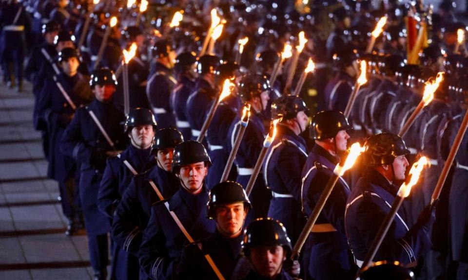 Soldiers hold torches as Germany’s outgoing chancellor, Angela Merkel, attends the grand tattoo of the German armed forces, Bundeswehr,