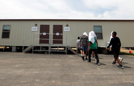 Immigrants head to a call center at the U.S. government's newest holding center for migrant children in Carrizo Springs