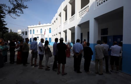 People wait to cast their votes at a polling station during presidential election in Tunis